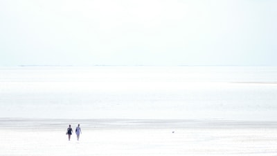两人走在白天冰雪覆盖领域
